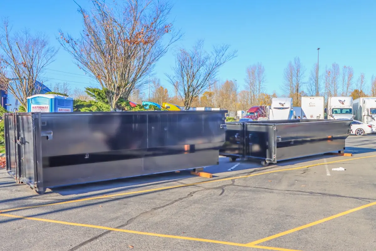 Professional dumpster rental service with roll-off container on residential driveway in Preston